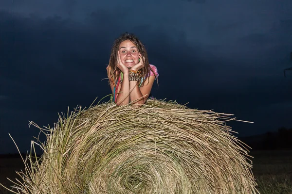 Flickan hoppar på ett hö-fält — Stockfoto