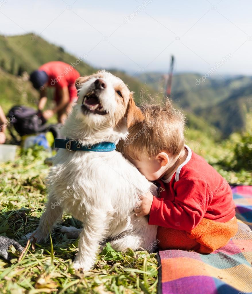 small child playing with a dog on the nature