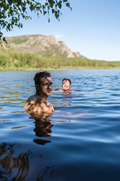 Az emberek egy festői hegyi tó fürödni — Stock Fotó