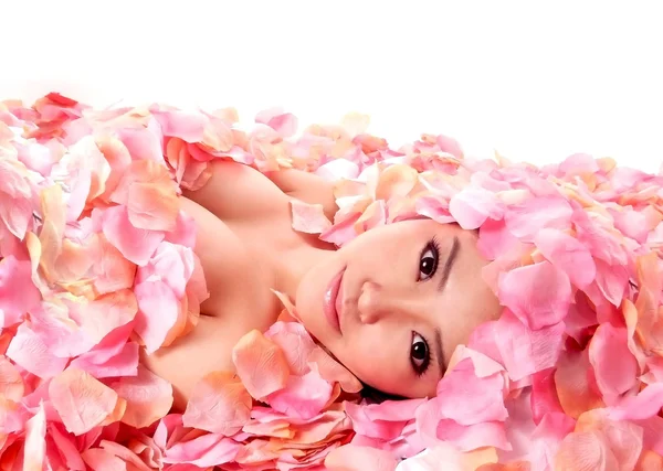 Азиатка в лепестках роз — стоковое фото