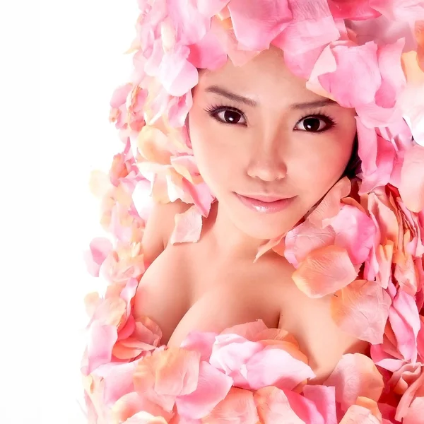 Asiatisk tjej i rosenblad Stockbild
