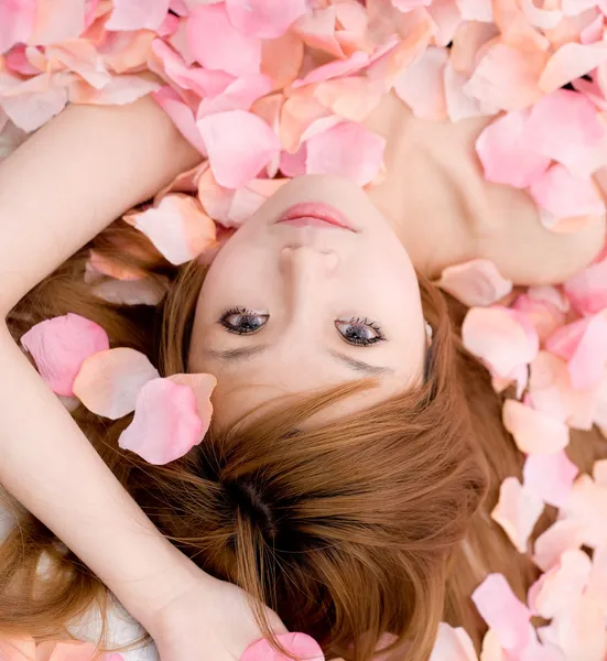 Asiatisk tjej i rosenblad Stockbild