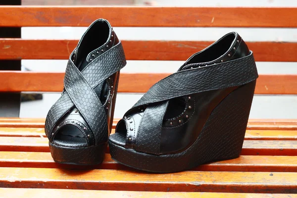 Sapatos de mulher em um banco — Fotografia de Stock