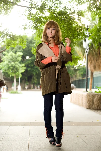 Asiática chica en un abrigo posando en el parque —  Fotos de Stock