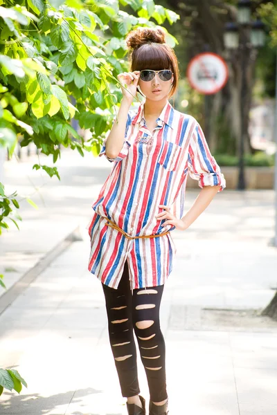 Asien flicka i solglasögon poserar utomhus — Stockfoto