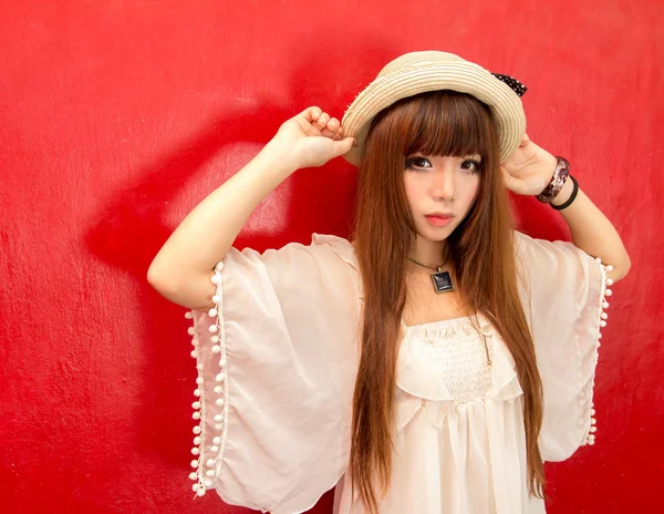 Fashionable girl in hat over a red background — Stock Photo, Image