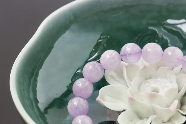 Purpurowy bransoletki i lily kamień w wodzie — Zdjęcie stockowe