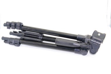 Beyaz arkaplanda seçici odaklı siyah tripod