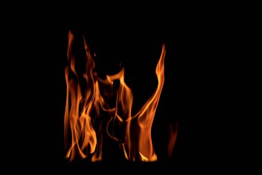 Grafik tasarımı ya da duvar kağıdı için yanan alevleri siyah arkaplanda kapat. Kırmızı ve sarı, ısı enerjisi gece boyunca yakıtı ateşliyor. Yemek pişirmek için kullanılan soyut ateş..