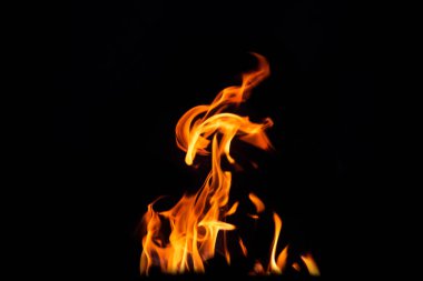 Grafik tasarımı ya da duvar kağıdı için yanan alevleri siyah arkaplanda kapat. Kırmızı ve sarı, ısı enerjisi gece boyunca yakıtı ateşliyor. Yemek pişirmek için kullanılan soyut ateş..