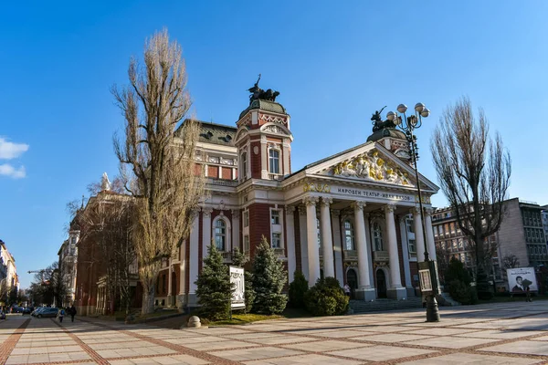 Sofia, Bulgarien - 1 mars 2021: Framför byggnaden av den bulgariska nationalteatern Ivan Vazov. Omgivande torg och gata på vintern. Historisk byggnad för kulturevenemang — Stockfoto