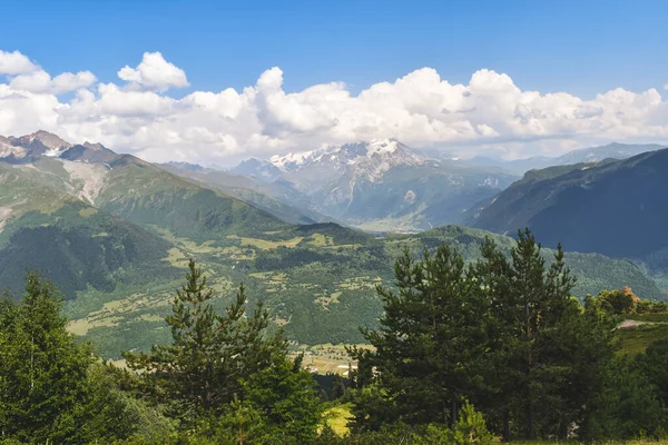 Nyári hegyvidéki táj közelében Mestia, Szvaneti régió, Grúzia, Ázsia. Snowcapapped hegyek a háttérben. Kék ég, felhőkkel felettünk. Grúzia úti célja — Stock Fotó