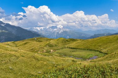 Svaneti bölgesinde yaz dağı manzarası, Gürcistan, Asya. Arka planda karlı dağlar var. Üzerinde bulutlar olan mavi gökyüzü. Gürcistan 'a seyahat