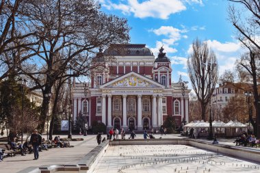 Sofya, Bulgaristan - 13 Mart 2021: Arka planda Bulgar Ulusal Tiyatrosu İvan Vazov 'un inşa edildiği şehir merkezine park edin. Kışın sokaklar