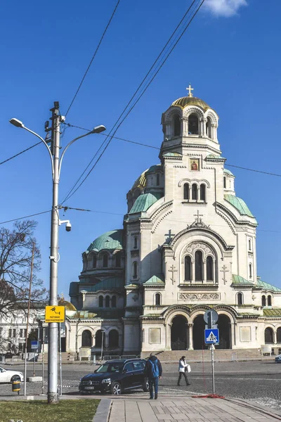 Sofia, Bulgaria - 1 marzo 2021: Cattedrale di Alexander Nevsky e piazza vicina con persone e auto. Cattedrale ortodossa bulgara nella capitale della Bulgaria. Costruito in stile neo-bizantino — Foto Stock