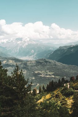 Mestia, Svaneti bölgesi, Gürcistan, Asya yakınlarındaki yaz dağ manzarası. Arka planda karlı dağlar var. Üzerinde bulutlar olan mavi gökyüzü. Gürcistan 'a seyahat
