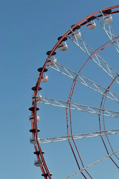 Roda gigante no parque de diversões fotografado contra o sol. Construção da atração com céu rosa e nuvens no fundo. Aventura, conceito de férias, conceitual — Fotografia de Stock