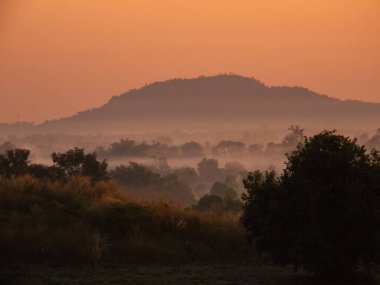 Amazing Sunrise Over Misty Landscape. Scenic View Of Foggy Morning Sky With Rising Sun Above Misty Forest