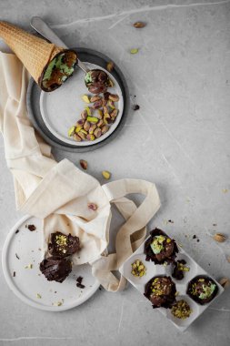 Pistachios ice-cream with pistachios nuts on ceramic plates with chocolate eggs 