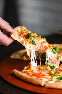 Salam peynirli mozzarella jambonlu ve yeşillikli pizza parçaları.