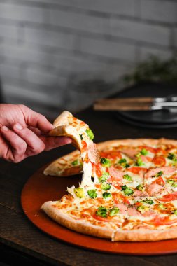 Salam peynirli mozzarella jambonlu ve yeşillikli pizza parçaları.