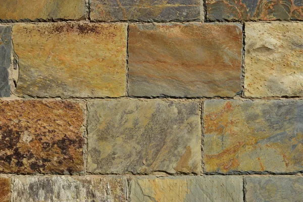 Pared hecha de bloques de piedra de colores — Foto de Stock