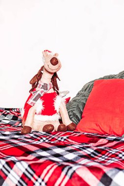 Yumuşak oyuncak Noel geyiği yatakta oturuyor ,