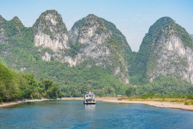 Turist gemisi Karst tepeleri boyunca ilerliyor. Li Nehri. Çin.
