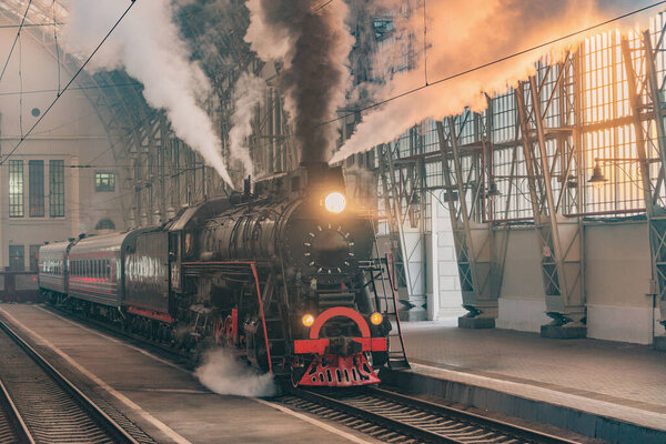 Ретро паровоз отправляется со станции в утреннее время.