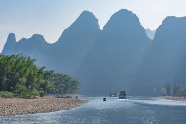 Turist gemisi Karst tepeleri boyunca ilerliyor. Li Nehri. Çin.
