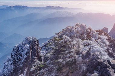 Huangshan Ulusal Parkı 'nın donmuş tepelerinde gün doğumu. Çin.