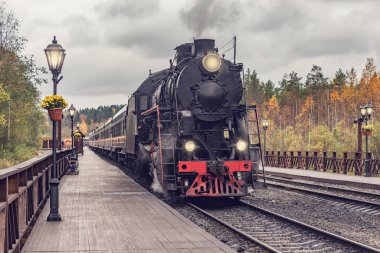 Retro buhar treni istasyon ahşap platformundan kalkıyor..