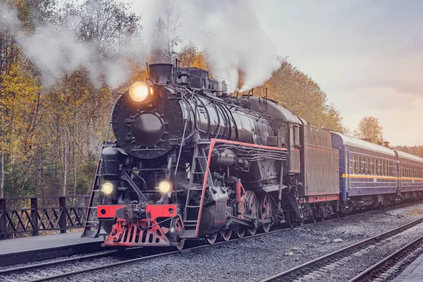 O trem a vapor retro parte da plataforma de madeira da estação. — Fotografia de Stock