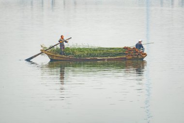 Şangay, Çin - 3 Ocak 2017: Çinli erkekler bambu ağaç gövdeleriyle denize açılır.