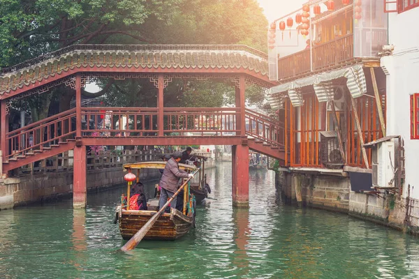 木造レトロボートは、古代中国の町の家に沿って移動します。. — ストック写真