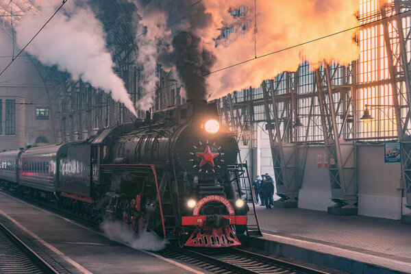Moscow, Russia - October 09, 2021: Retro steam train departs from the station at morning time.