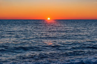 Yaz mevsiminde deniz ufkunun gün batımı manzarası.