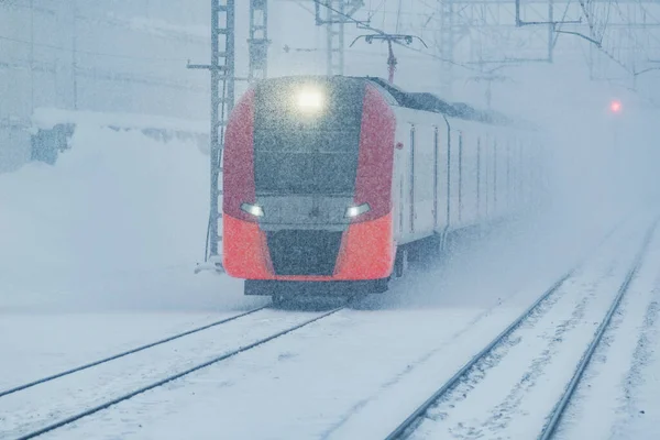 冷たい吹雪の中で駅への高速列車の接近 — ストック写真