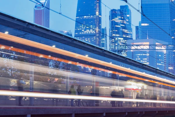 Moderno treno ad alta velocità si muove sullo sfondo del business center . — Foto Stock