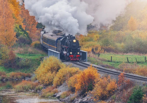 O trem a vapor retro se move ao longo do lago na manhã de outono. Carélia. — Fotografia de Stock