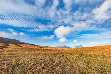 Sonbahar günbatımında dağ çayırının üzerindeki bulutlar.