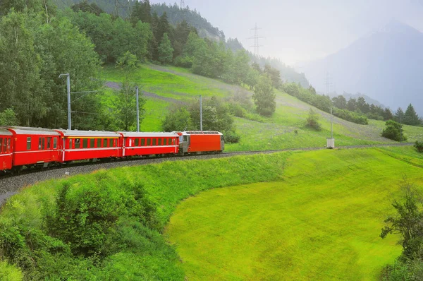 O comboio de passageiros vai de Chur para St. Moritz. Alpes suíços. — Fotografia de Stock