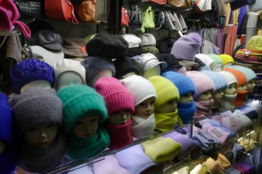 Sonbahar ve kış giysileri. Vitrindeki kış aksesuarları. Sıcak, yumuşak şapkalar, eldivenler ve eldivenler..