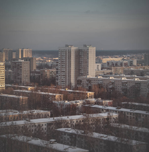 Rooftops and high residential buildings covered by snow. Winter snowy weather in the city. Heating season. Top view of Moscow on a winter day