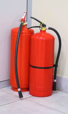 Two red fire extinguishers in an office or other public place. Fire protection.