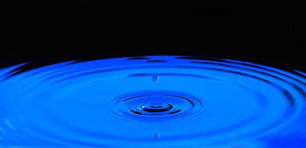 Droppe vatten i blått — Stockfoto