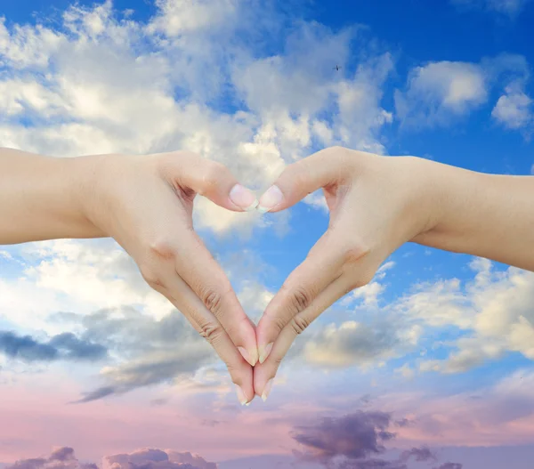 Hands shaping a heart on sky — Stock Photo, Image
