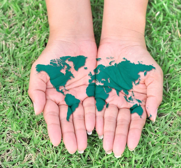 Map of the world in your hands with green grassy background — Stock Photo, Image