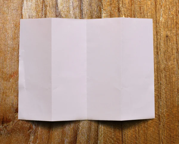 Old white paper sheet on wooden table — Stock Photo, Image