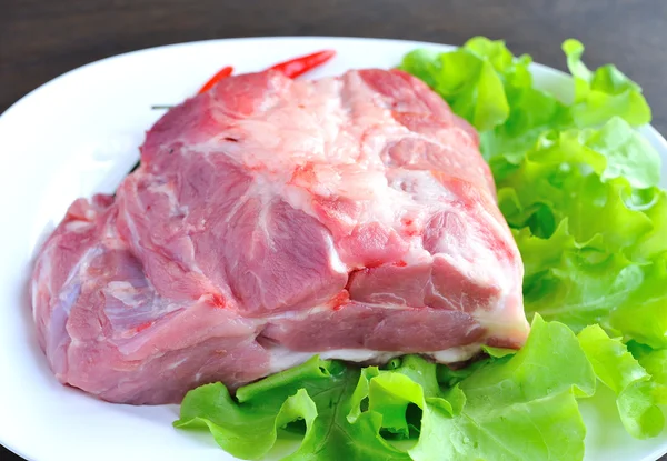 Rohes Schweinefleisch auf dem Teller mit Gemüse. — Stockfoto